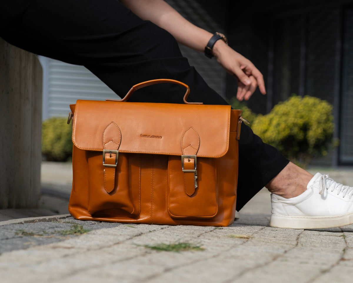 Brown leather laptop briefcase with handle, front pockets and buckle closures