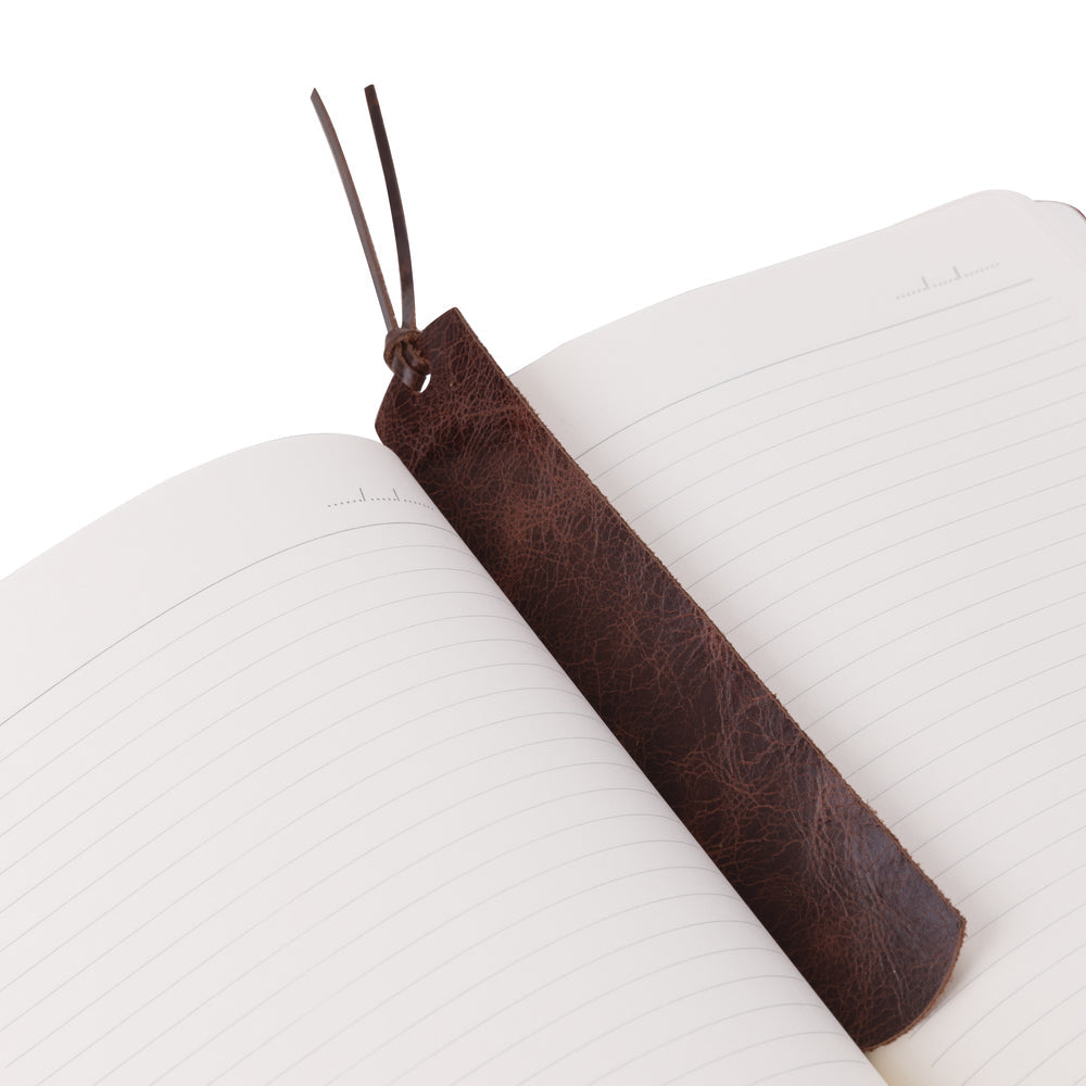 Brown leather bookmark on a white book