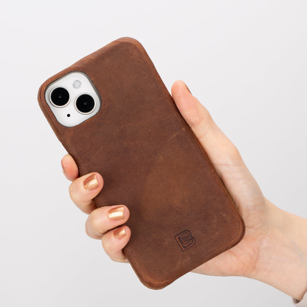 Hand holding a brown phone case with a blurred background