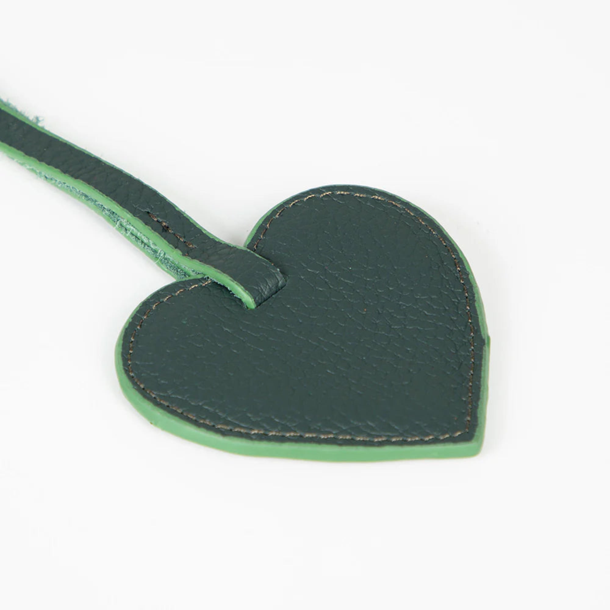 Green heart-shaped leather tag on a white background