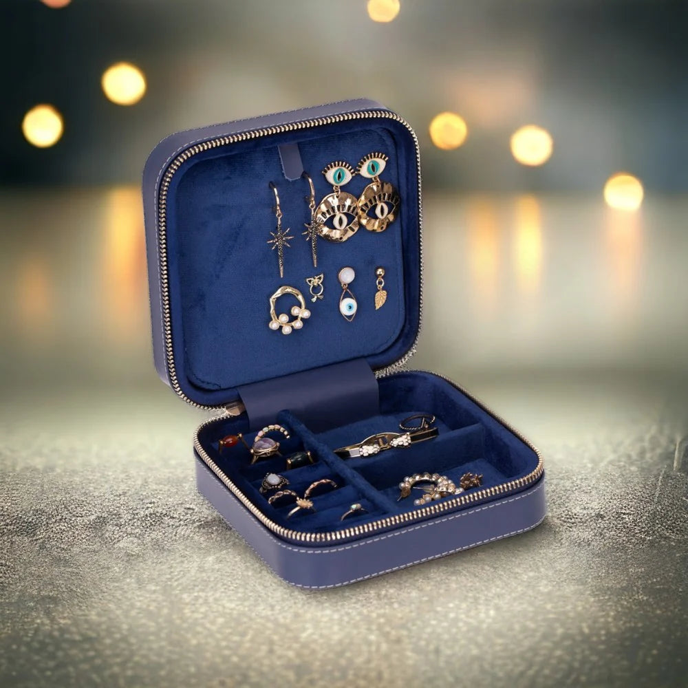 Open blue jewelry case with various earrings on a blurred background