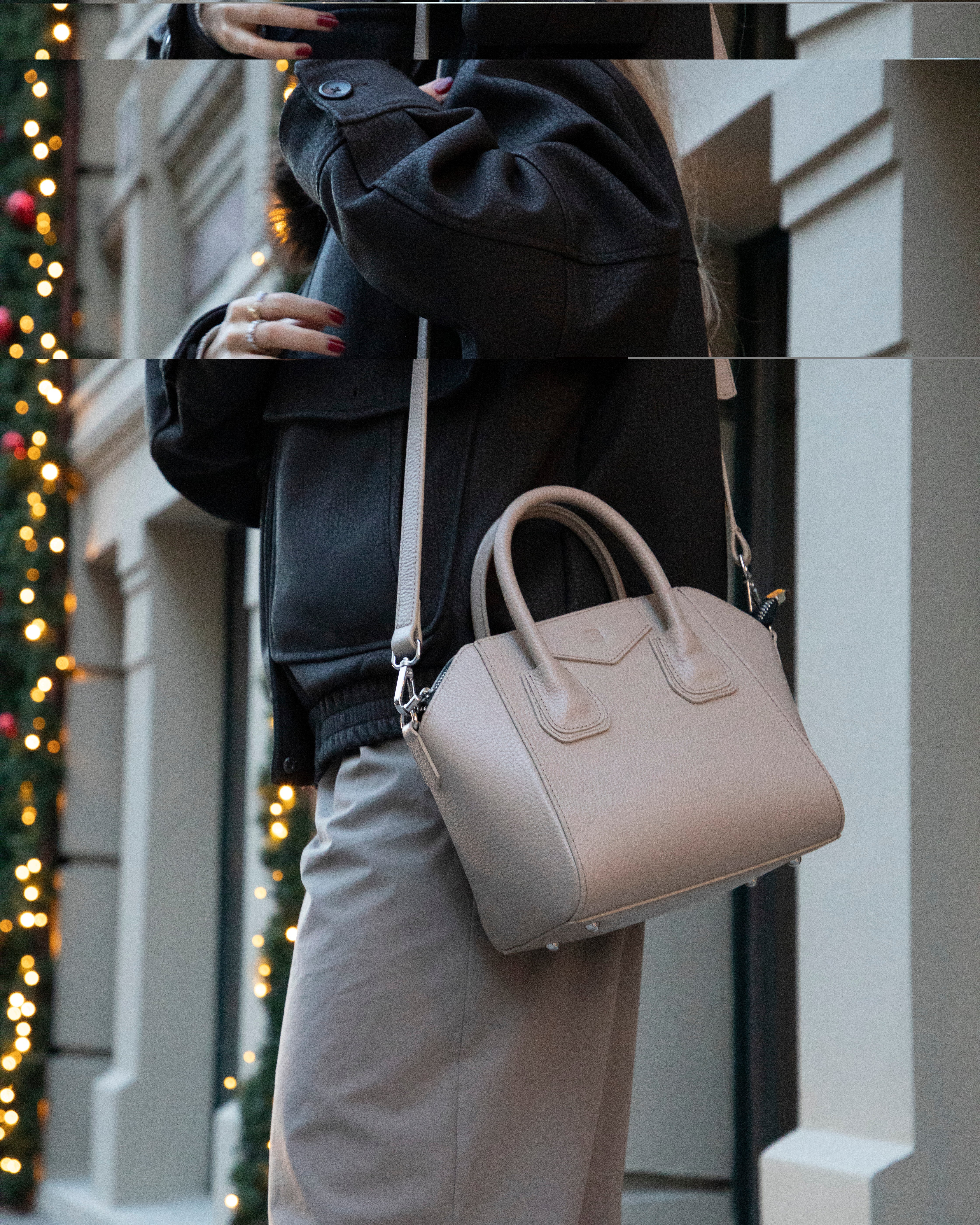 Person holding a beige handbag in an urban setting with blurred lights.