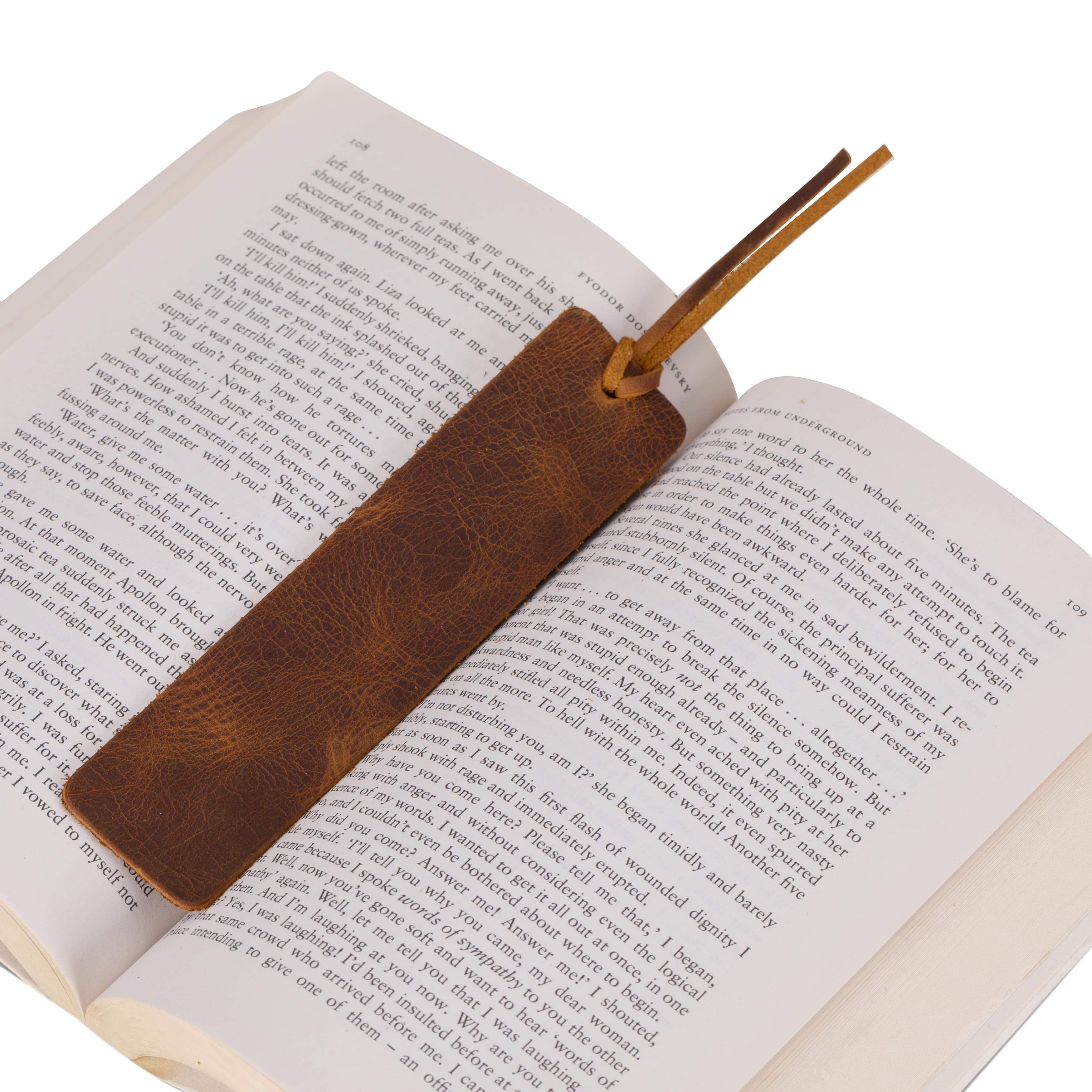 Brown leather bookmark on an open book with a white background
