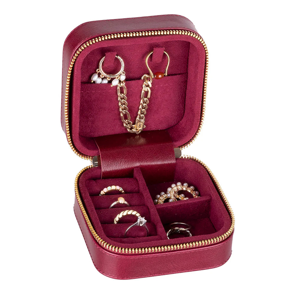 Red jewelry box with gold zipper containing jewelry on a white background