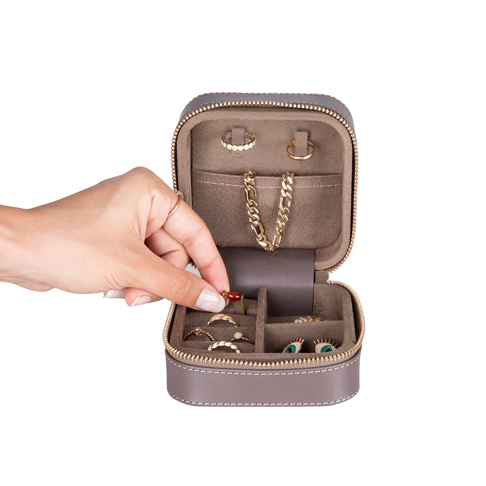 Jewelry organizer with gold chain, earrings, and rings on a white background