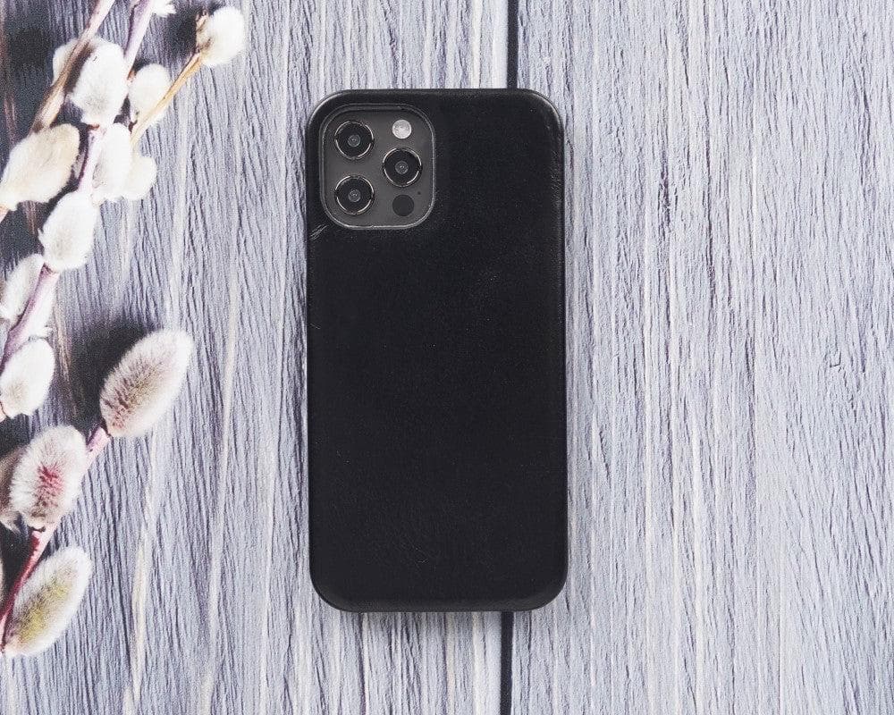 Black phone case on a wooden surface with floral branches