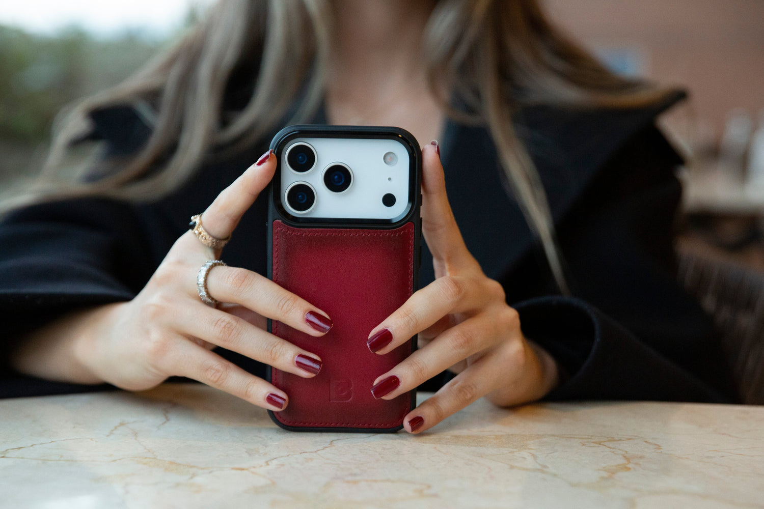 Red leather iPhone card holder case held in hands