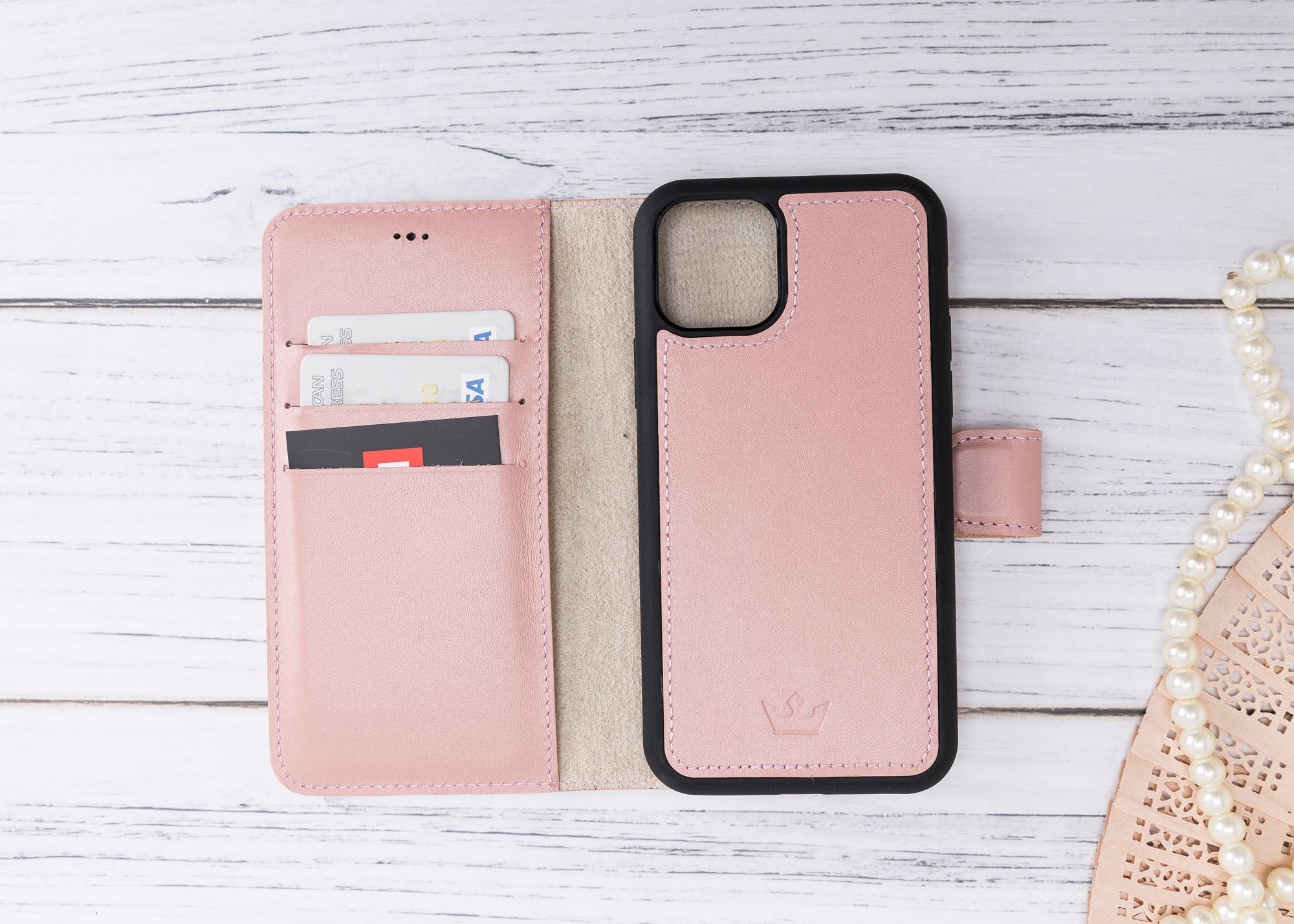 Pink phone case with card slots on a wooden surface