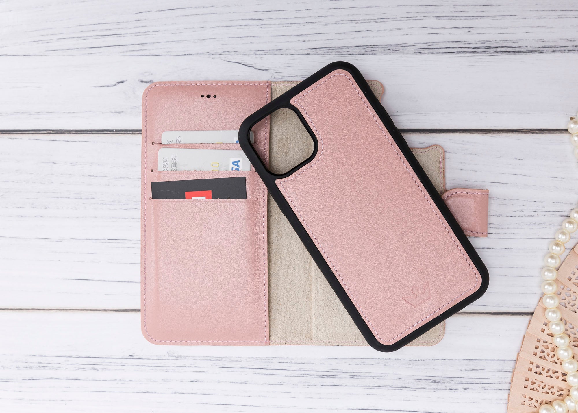 Pink phone case with black accents on a wooden surface