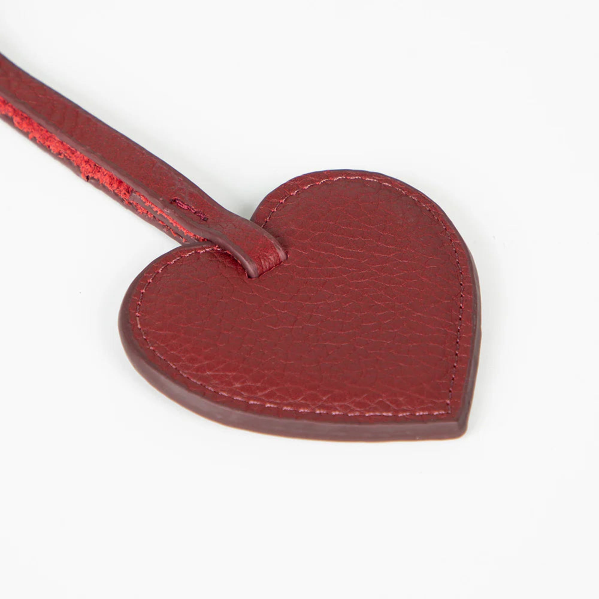 Red heart-shaped charm on a white background
