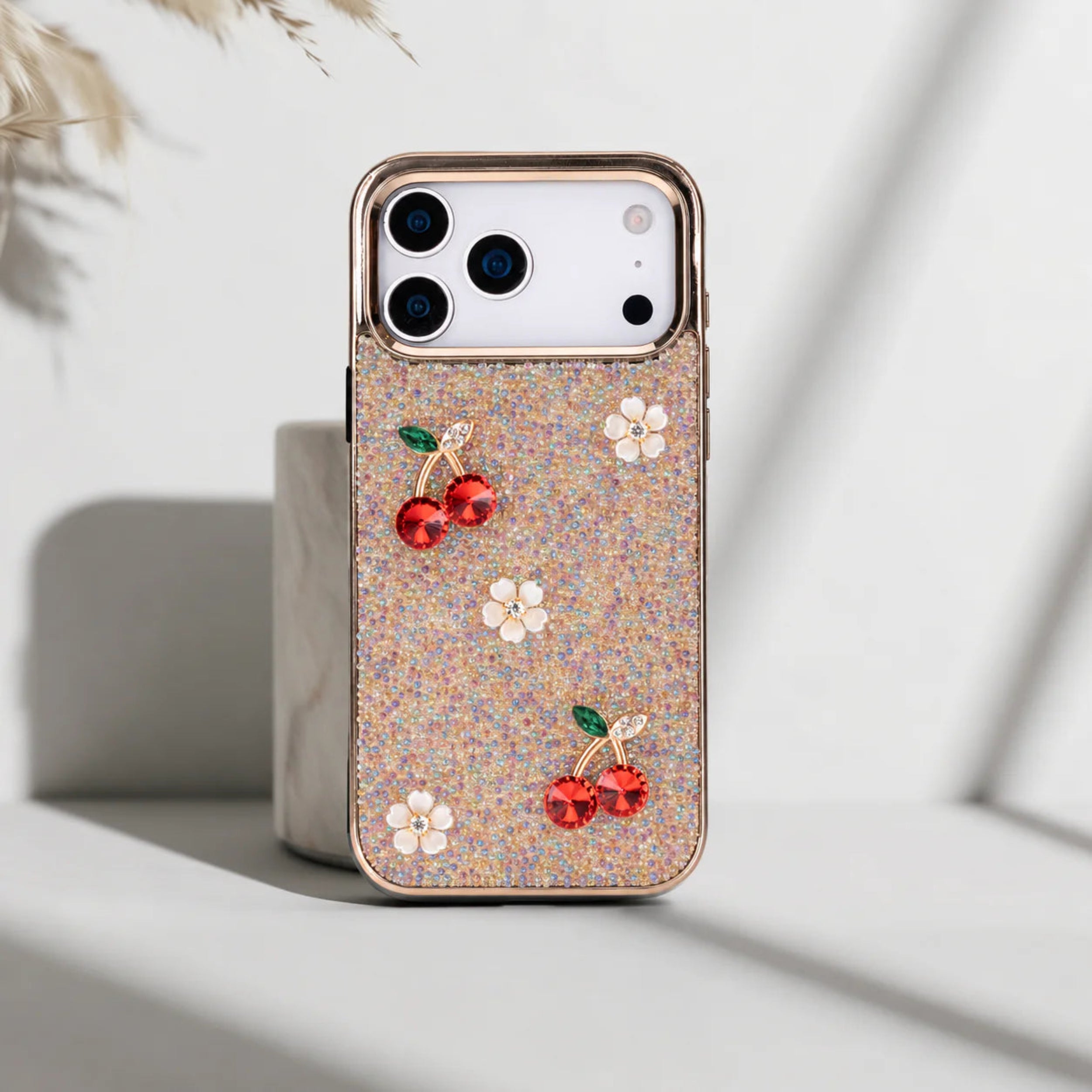 Phone case with cherry and flower designs on a light background