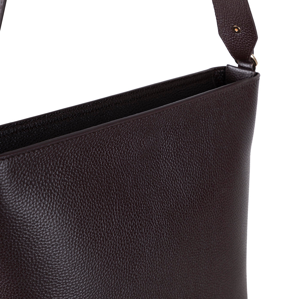 Close-up of a black leather handbag with a strap on a white background