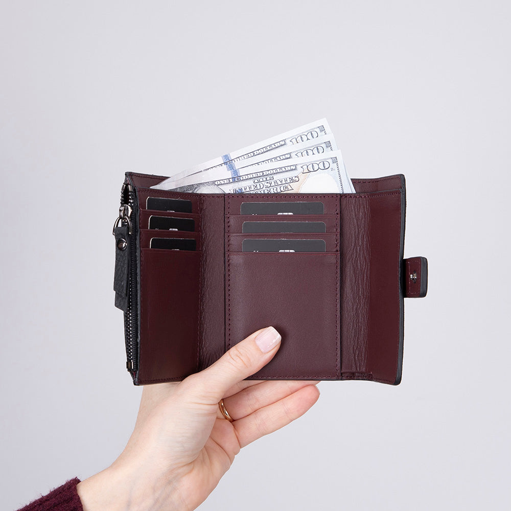 Black genuine leather women’s wallet with burgundy strap and flap closure