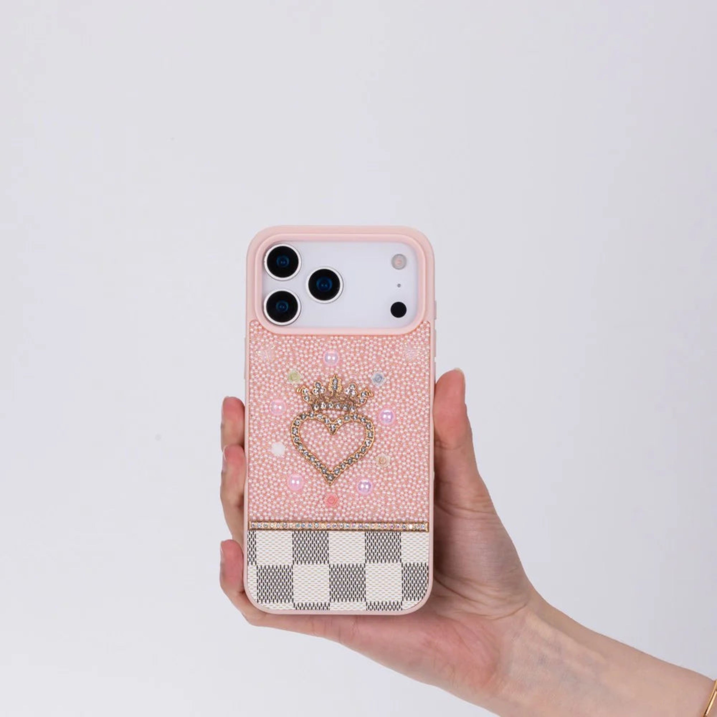 Phone case with decorative design held by a hand on a light gray background