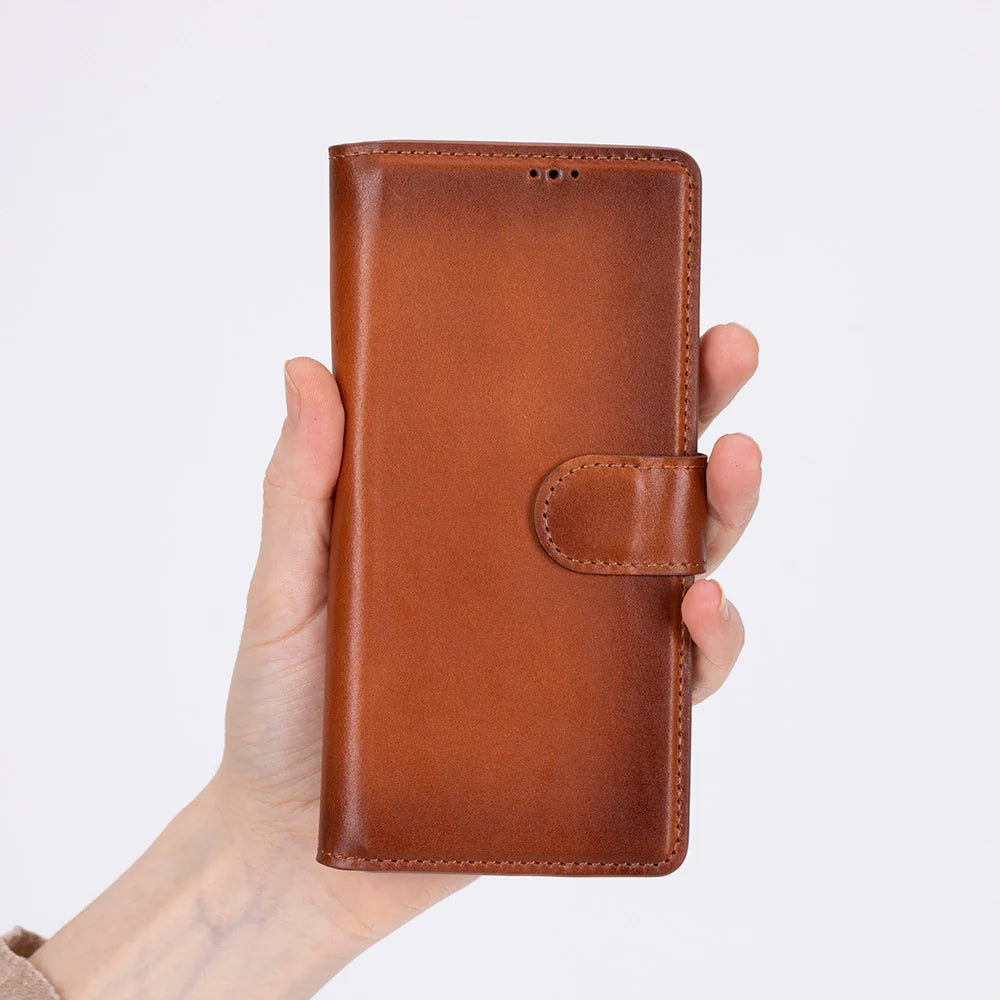 Brown leather phone case held in a hand against a light gray background