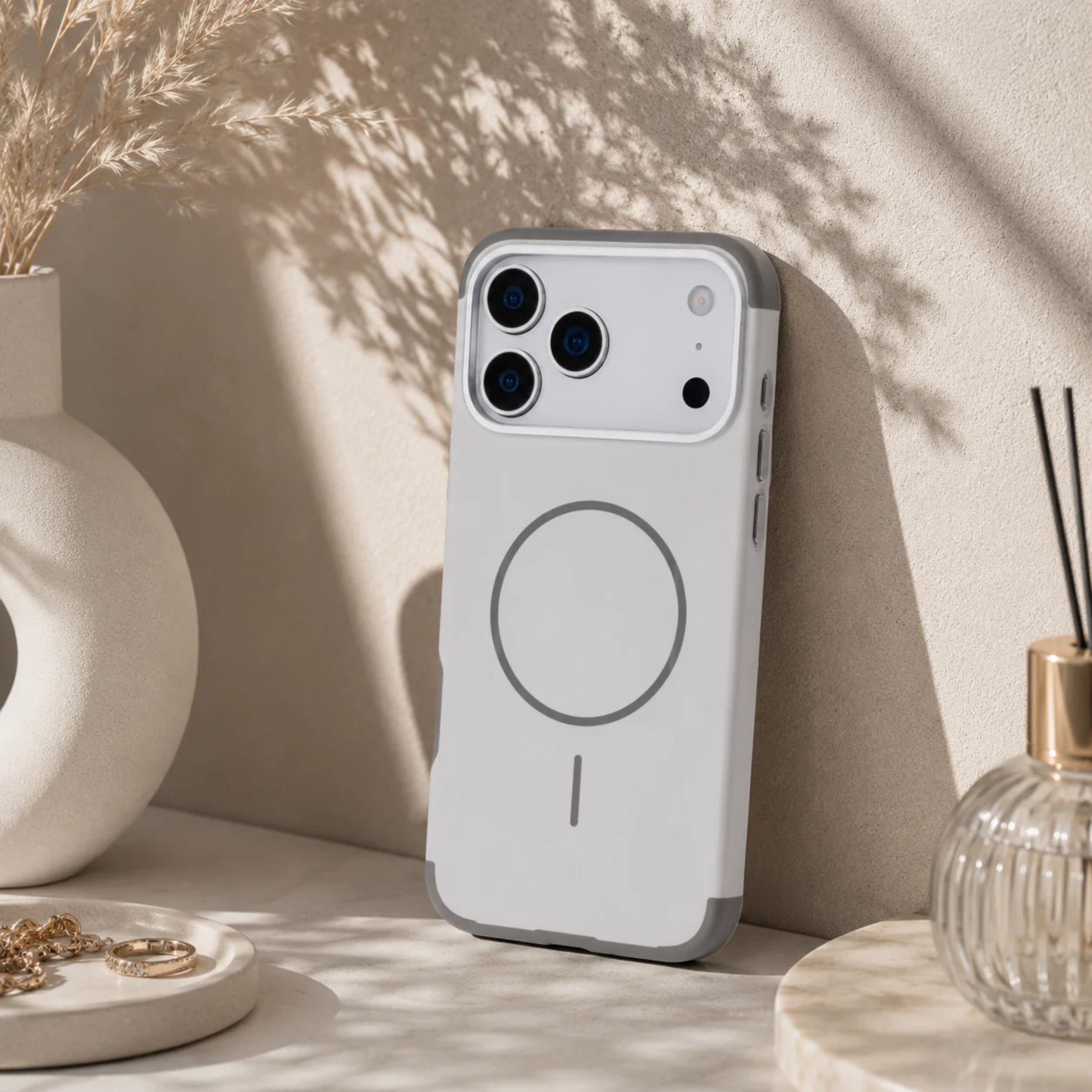 Phone case with magnetic design on a decorative surface with plants and decor items.