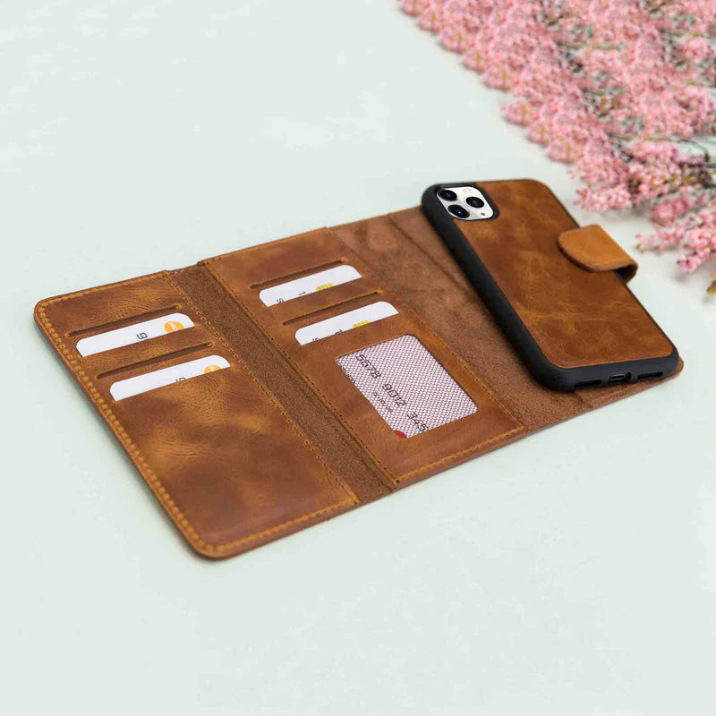 Brown leather phone wallet with card slots on a light surface with pink flowers.